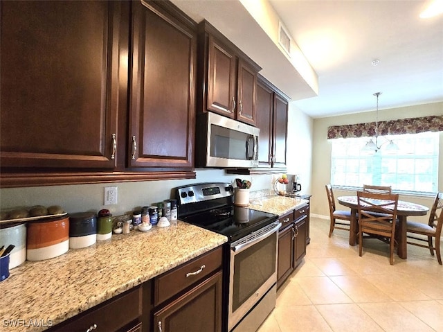 kitchen featuring visible vents, light stone counters, stainless steel appliances, dark brown cabinets, and pendant lighting