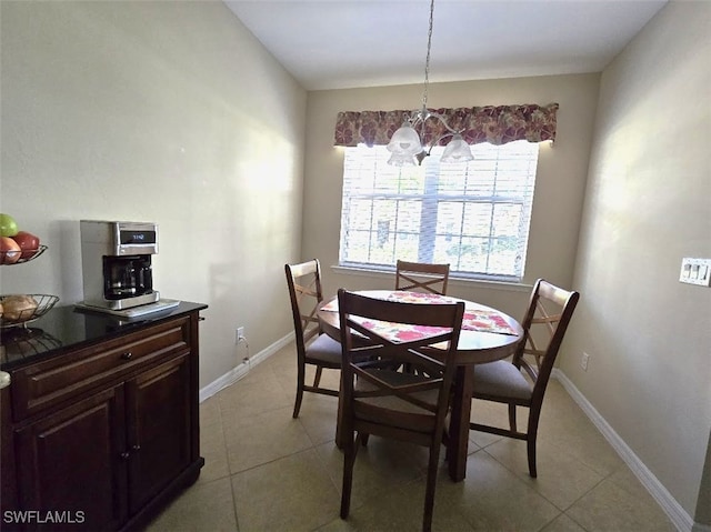 dining space featuring an inviting chandelier, light tile patterned floors, and baseboards