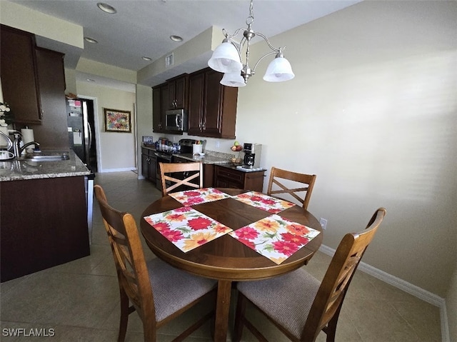 tiled dining area featuring visible vents, baseboards, a chandelier, a sink, and recessed lighting