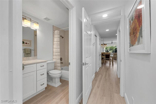 full bath with shower / bath combination with curtain, visible vents, toilet, vanity, and wood finished floors