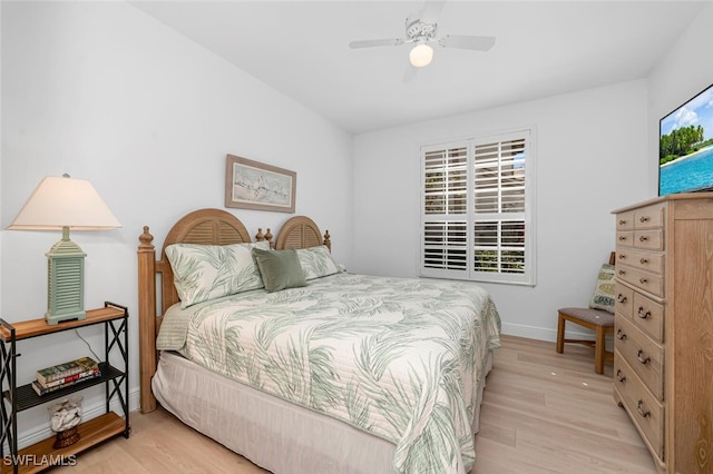 bedroom with light wood finished floors, baseboards, and a ceiling fan