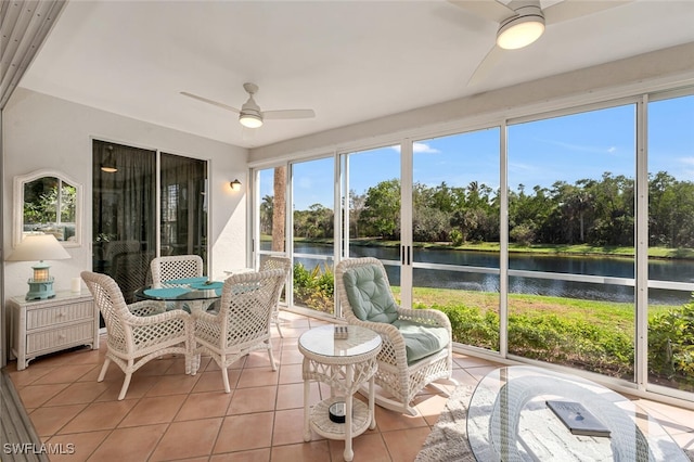 sunroom / solarium with a ceiling fan and a water view