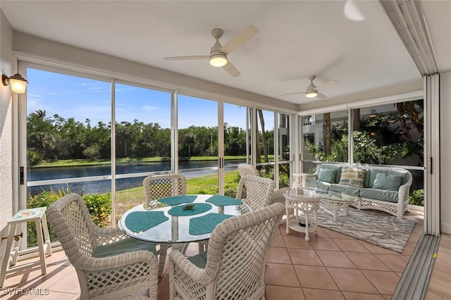 sunroom featuring ceiling fan and a water view