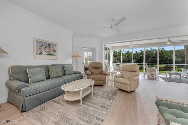 living room with light wood-style floors, a sunroom, and crown molding