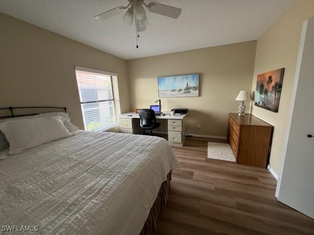 bedroom featuring dark wood-style floors, ceiling fan, and baseboards