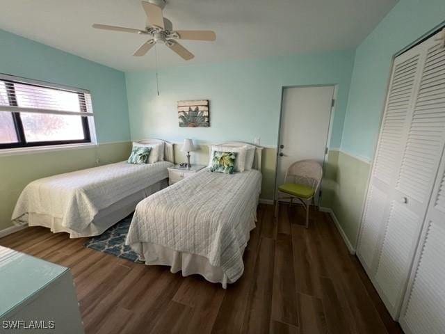 bedroom with dark wood-style flooring, a closet, a ceiling fan, and baseboards