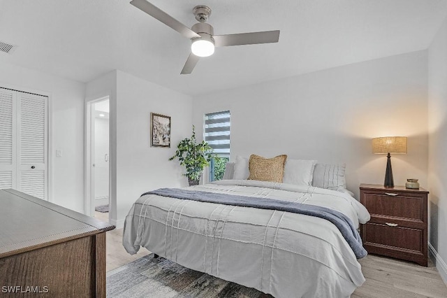 bedroom featuring light wood finished floors, a closet, visible vents, ceiling fan, and baseboards