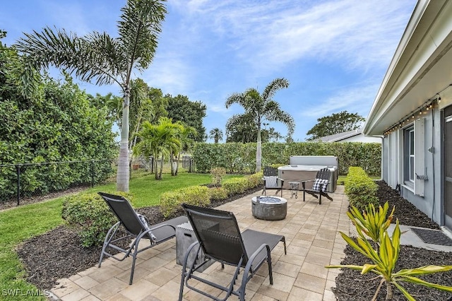 view of patio featuring an outdoor fire pit, a fenced backyard, and a hot tub