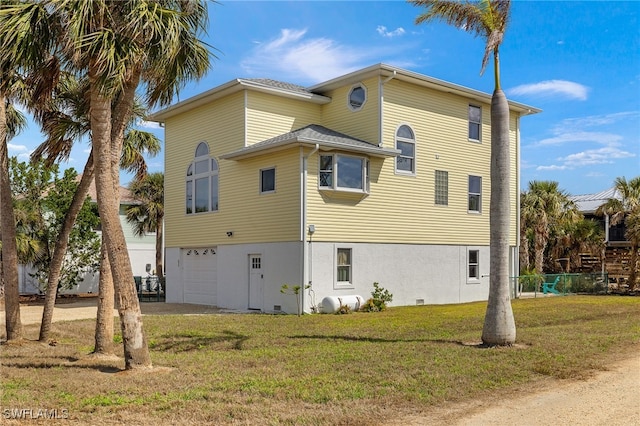 view of side of property with a garage, a lawn, and stucco siding