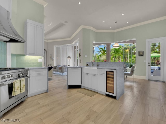 7627 Palmer Ct, Naples, FL 34113 - kitchen with white cabinets, stainless steel range, a sink, under cabinet range hood, and beverage cooler