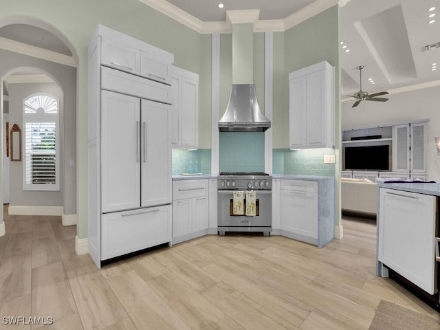 7627 Palmer Ct, Naples, FL 34113 - kitchen featuring light countertops, a ceiling fan, white cabinetry, wall chimney exhaust hood, and premium appliances