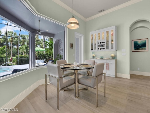 7627 Palmer Ct, Naples, FL 34113 - dining room featuring visible vents, baseboards, crown molding, and light wood-style flooring