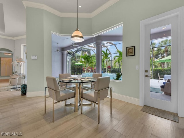 7627 Palmer Ct, Naples, FL 34113 - dining space with ornamental molding, light wood-style flooring, a high ceiling, and baseboards