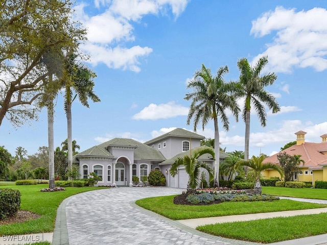 view of front facade with a garage, decorative driveway, and a front yard