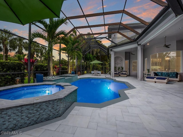7627 Palmer Ct, Naples, FL 34113 - pool at dusk with an outdoor living space, a pool with connected hot tub, a ceiling fan, a patio, and a lanai
