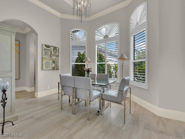 7627 Palmer Ct, Naples, FL 34113 - dining space featuring arched walkways, baseboards, ornamental molding, and light wood-type flooring