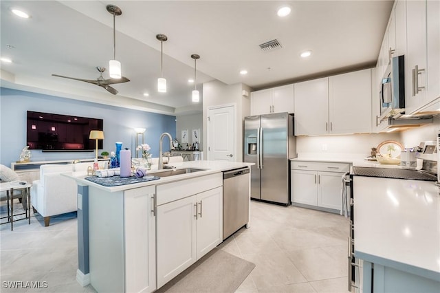 kitchen with stainless steel appliances, light countertops, and white cabinetry