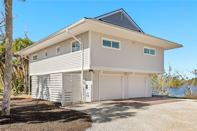 view of side of home with driveway and a garage