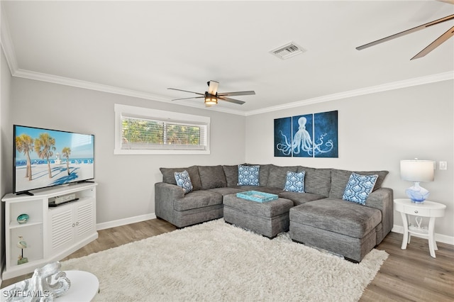 living area featuring visible vents, wood finished floors, ornamental molding, and a ceiling fan