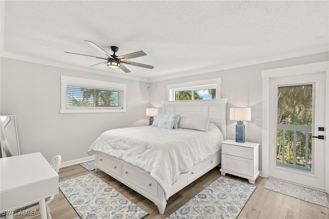 bedroom with a textured ceiling, crown molding, ceiling fan, and wood finished floors