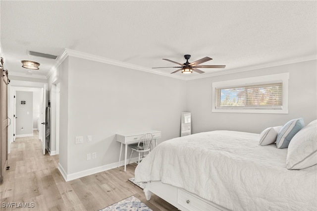 bedroom with baseboards, visible vents, ornamental molding, light wood-style floors, and a textured ceiling