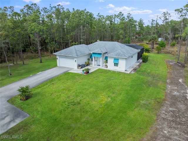 ranch-style home featuring a garage, aphalt driveway, and a front yard