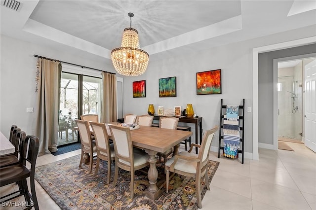 dining area featuring light tile patterned floors, a notable chandelier, visible vents, baseboards, and a raised ceiling