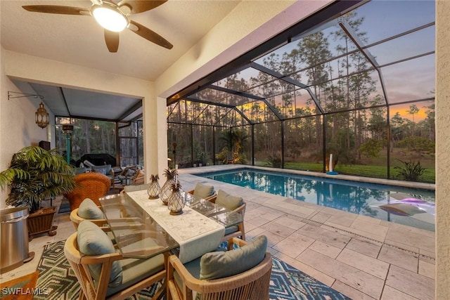 pool featuring a grill, a patio area, glass enclosure, and ceiling fan