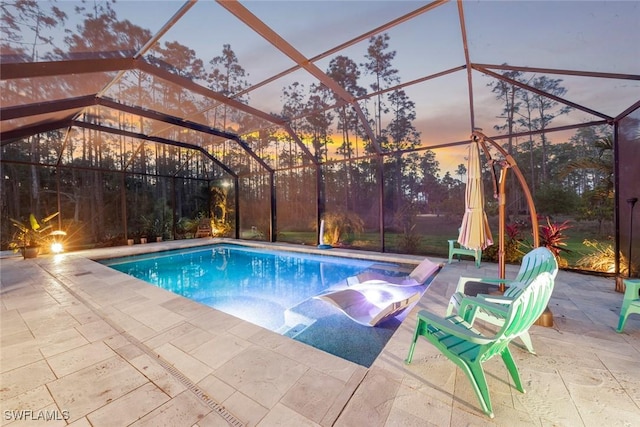 pool featuring glass enclosure and a patio