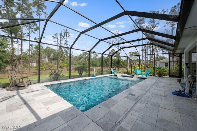 outdoor pool featuring glass enclosure, a hot tub, and a patio