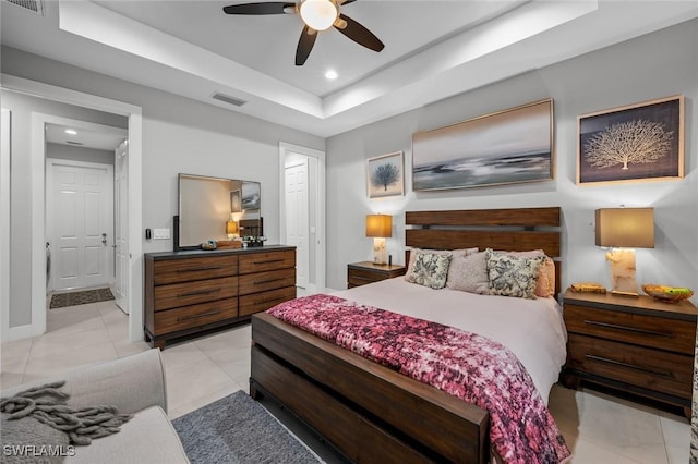 bedroom with baseboards, visible vents, a raised ceiling, and light tile patterned flooring