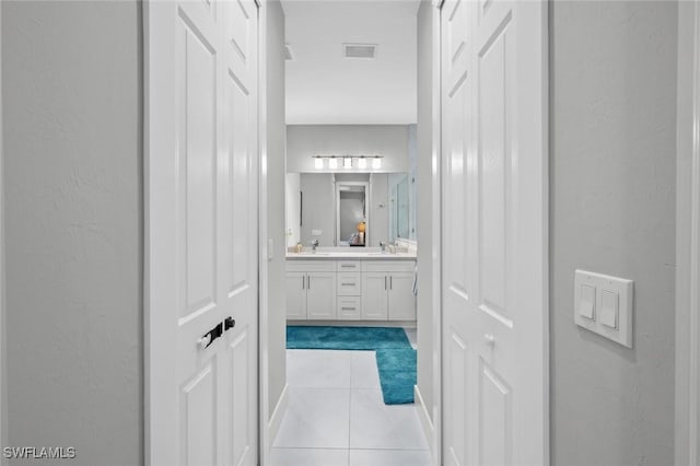 full bathroom featuring a sink, double vanity, tile patterned flooring, and visible vents