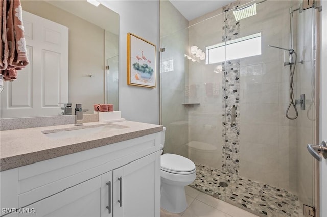 bathroom with toilet, vanity, a shower stall, and tile patterned floors