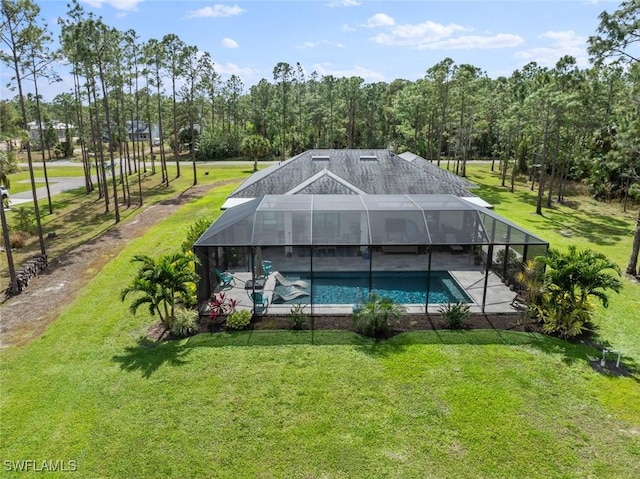 outdoor pool with a patio, a lawn, and a lanai