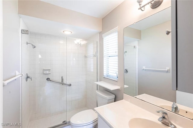 bathroom featuring a shower stall, toilet, and vanity