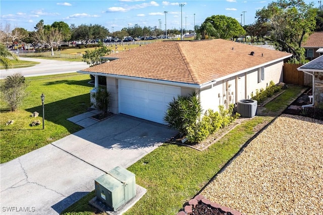 exterior space featuring roof with shingles, central air condition unit, a front yard, a garage, and driveway