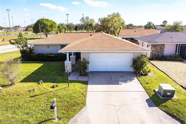 single story home with a garage, a shingled roof, concrete driveway, a front yard, and stucco siding