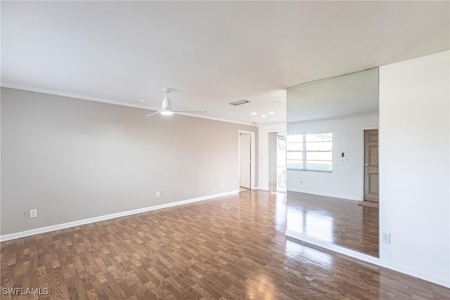 spare room featuring baseboards, wood finished floors, a ceiling fan, and crown molding