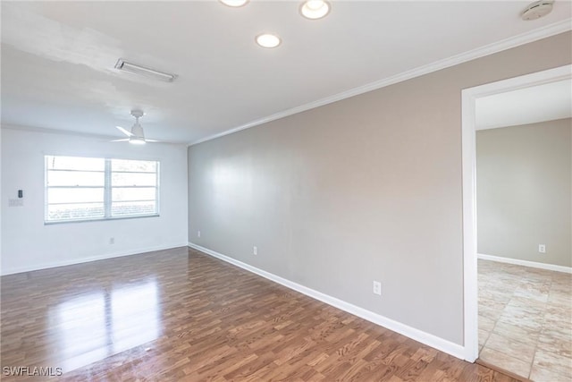 unfurnished room featuring ornamental molding, wood finished floors, visible vents, and baseboards