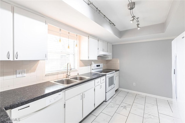 kitchen with a tray ceiling, marble finish floor, a sink, white appliances, and under cabinet range hood