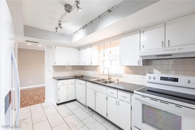 kitchen with dark countertops, decorative backsplash, a sink, white appliances, and under cabinet range hood