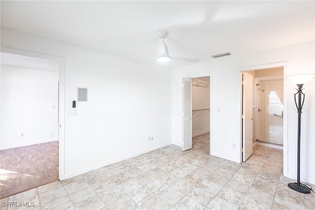 unfurnished bedroom with baseboards, visible vents, a ceiling fan, a spacious closet, and a closet