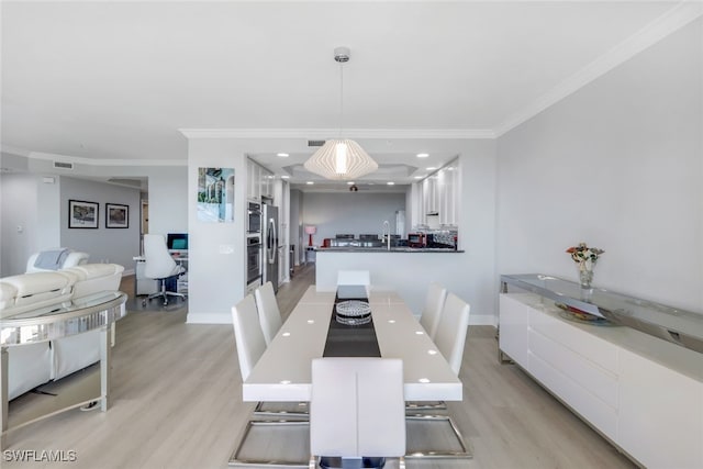 dining area with ornamental molding, baseboards, visible vents, and light wood finished floors