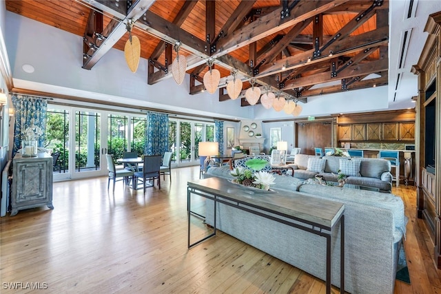 living room with light wood-style floors, wood ceiling, high vaulted ceiling, and beam ceiling