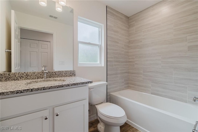 full bathroom with a closet, shower / bath combination, visible vents, toilet, and vanity