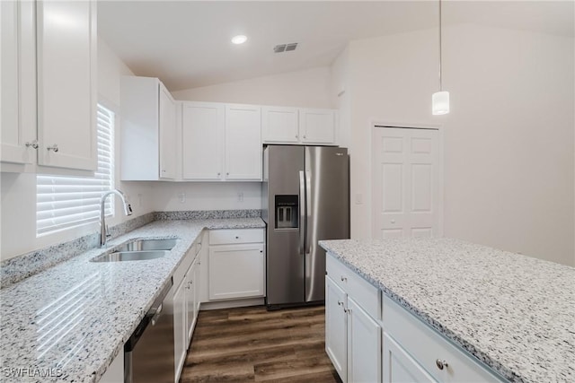 kitchen featuring light stone counters, stainless steel appliances, hanging light fixtures, white cabinets, and a sink