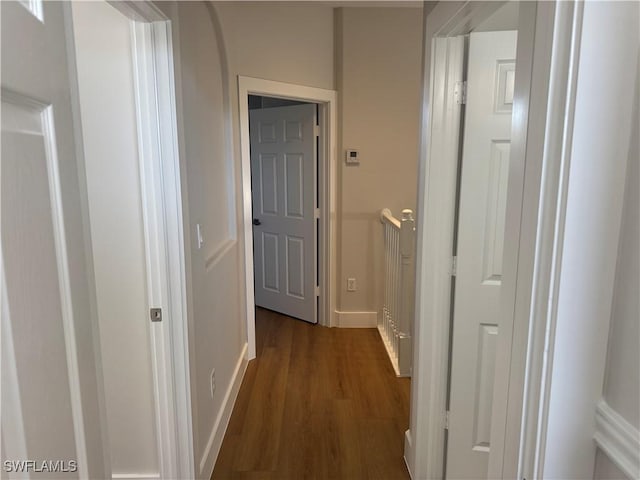 corridor with baseboards and dark wood finished floors