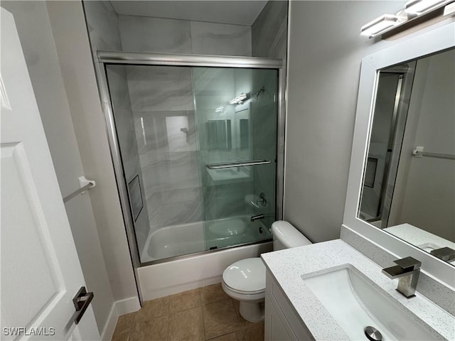 full bathroom featuring shower / bath combination with glass door, vanity, toilet, and tile patterned floors