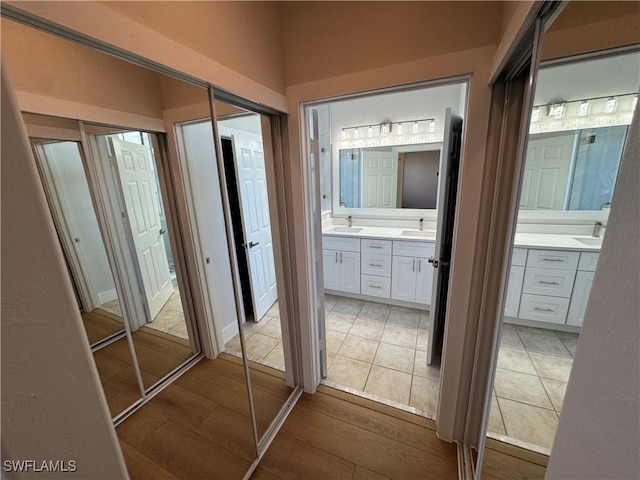 hallway featuring light wood-style floors and a sink