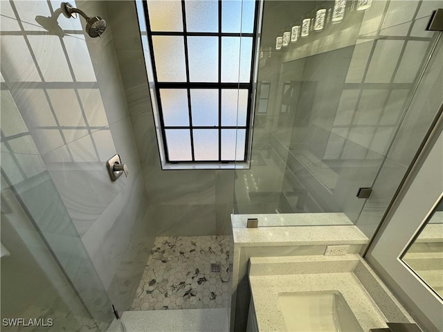 bathroom with a shower stall and vanity